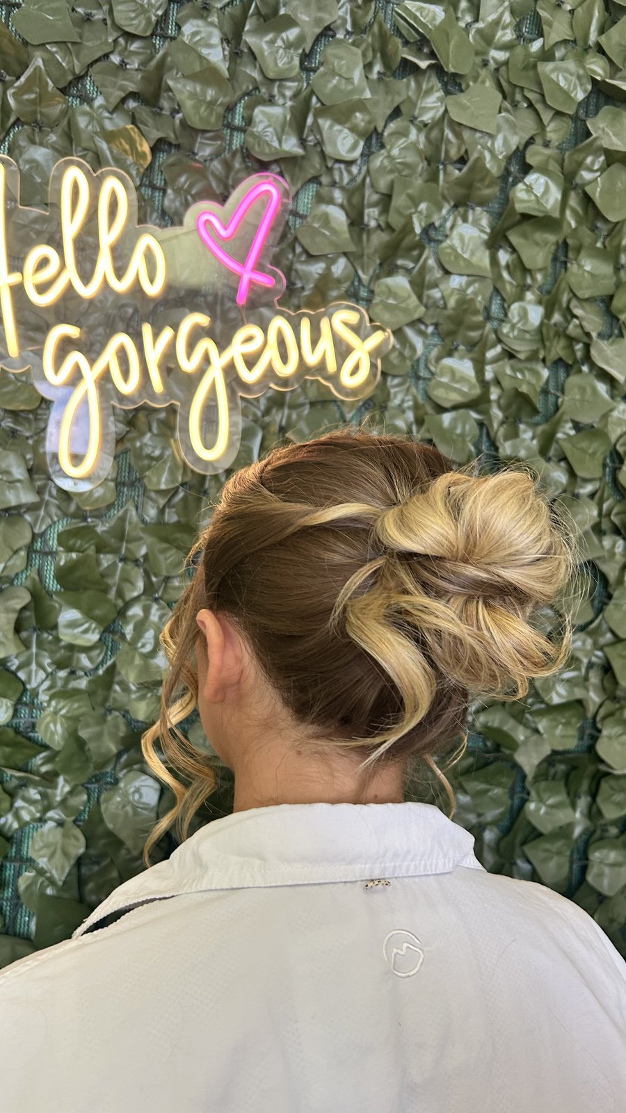 Modern messy bun updo with face-framing pieces.